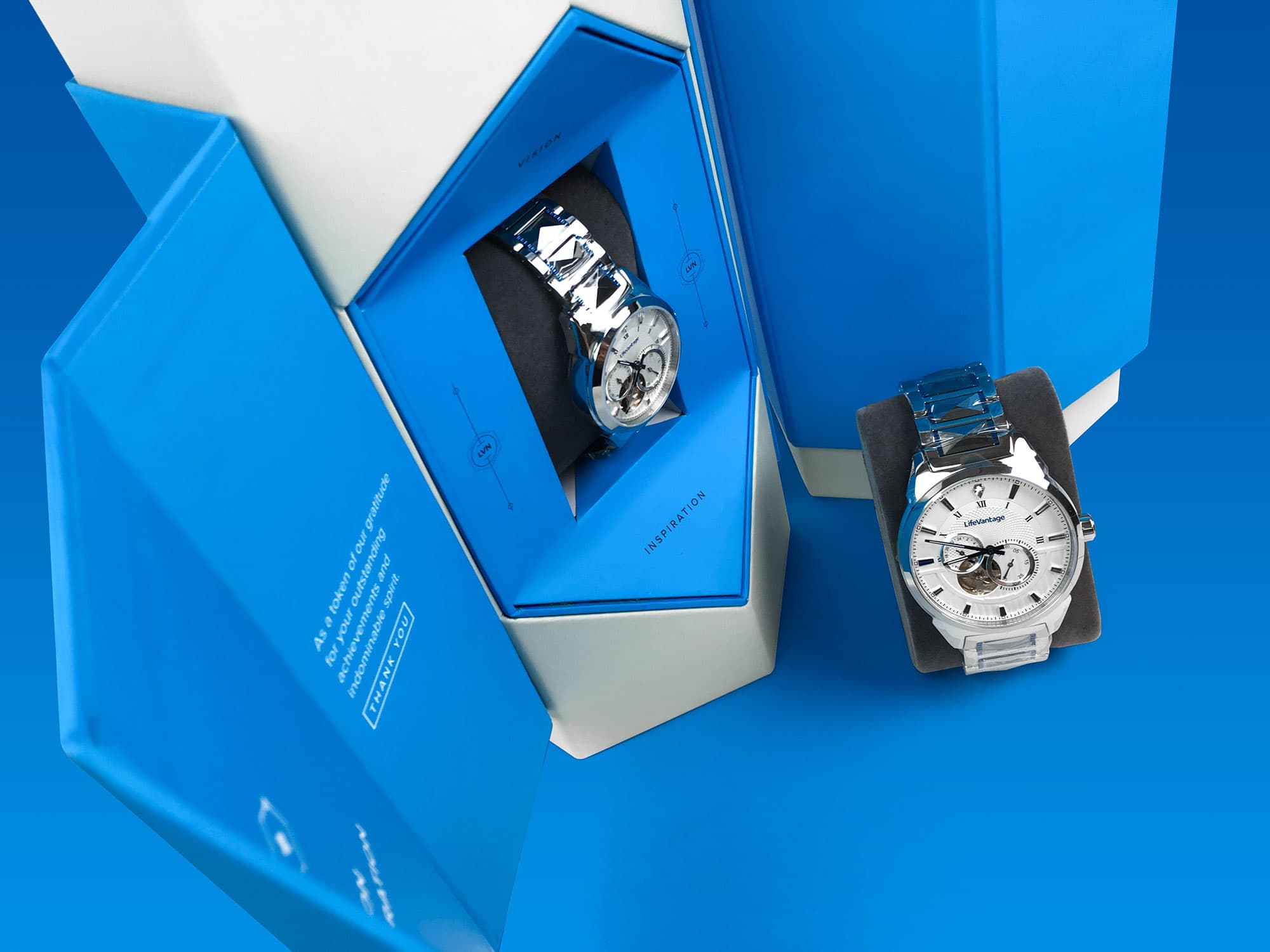 LifeVantage — custom blue rigid watch boxes with branded interior print, velvet cushion insert, and magnetic closure